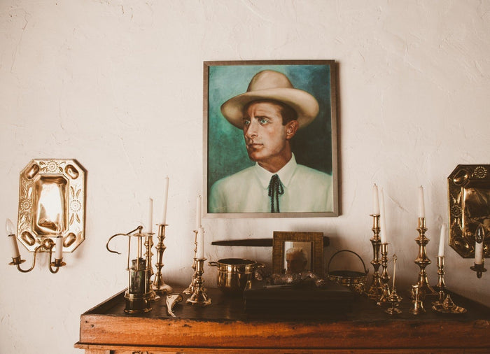 Portrait painting above a candlelit wooden sideboard at Santa Isabel