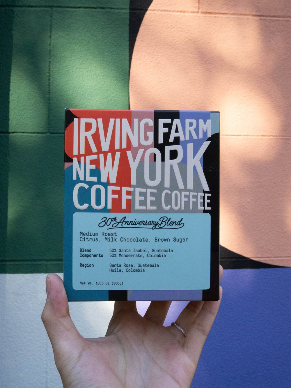 30th Anniversary Blend box held up in front of a New York mural